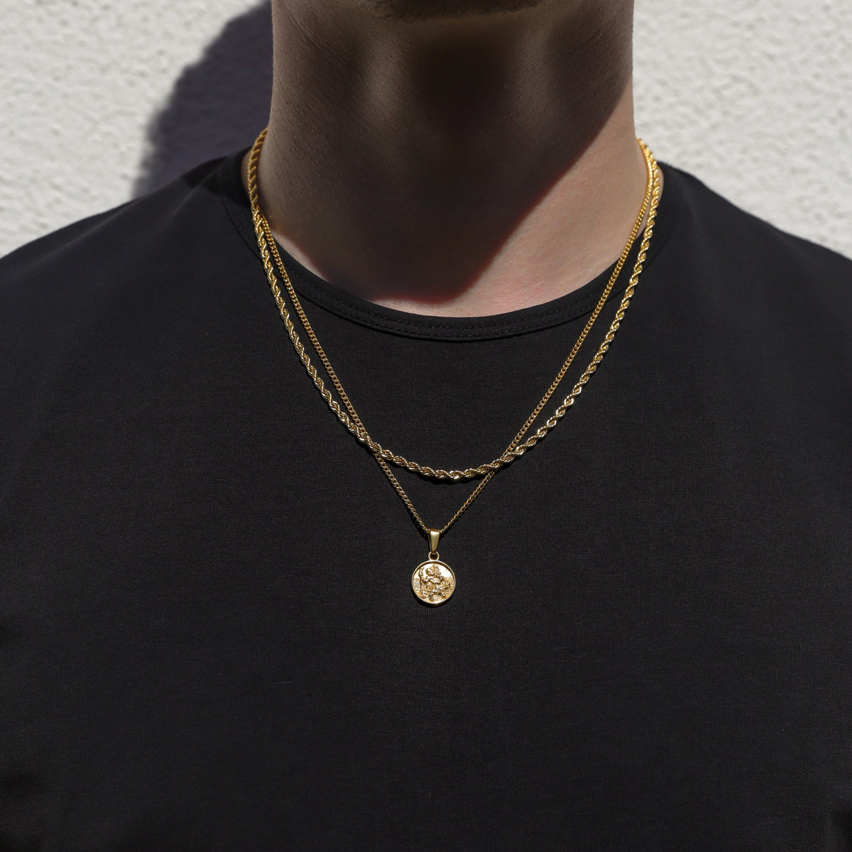 Two-layer gold rope necklace set with round Saint Christopher pendant on chest