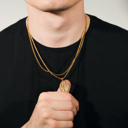 Gold Saint Mary pendant necklace on person, two chains with oval charm