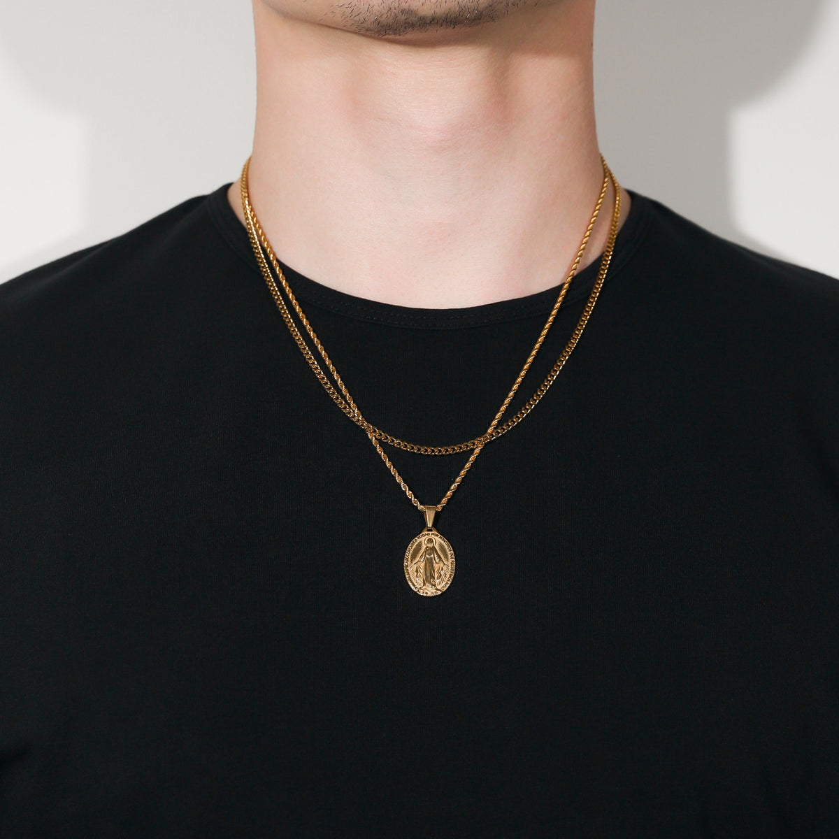 Gold Saint Mary pendant necklace on person, single oval charm centered
