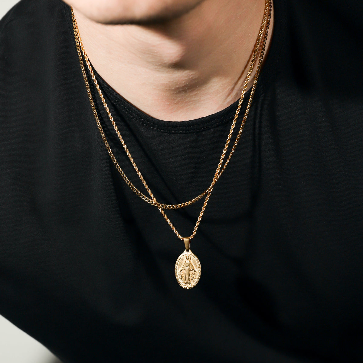 Gold layered necklace with dangling oval medallion pendant, fine chain links