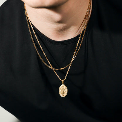 Gold layered necklace with dangling oval medallion pendant, fine chain links