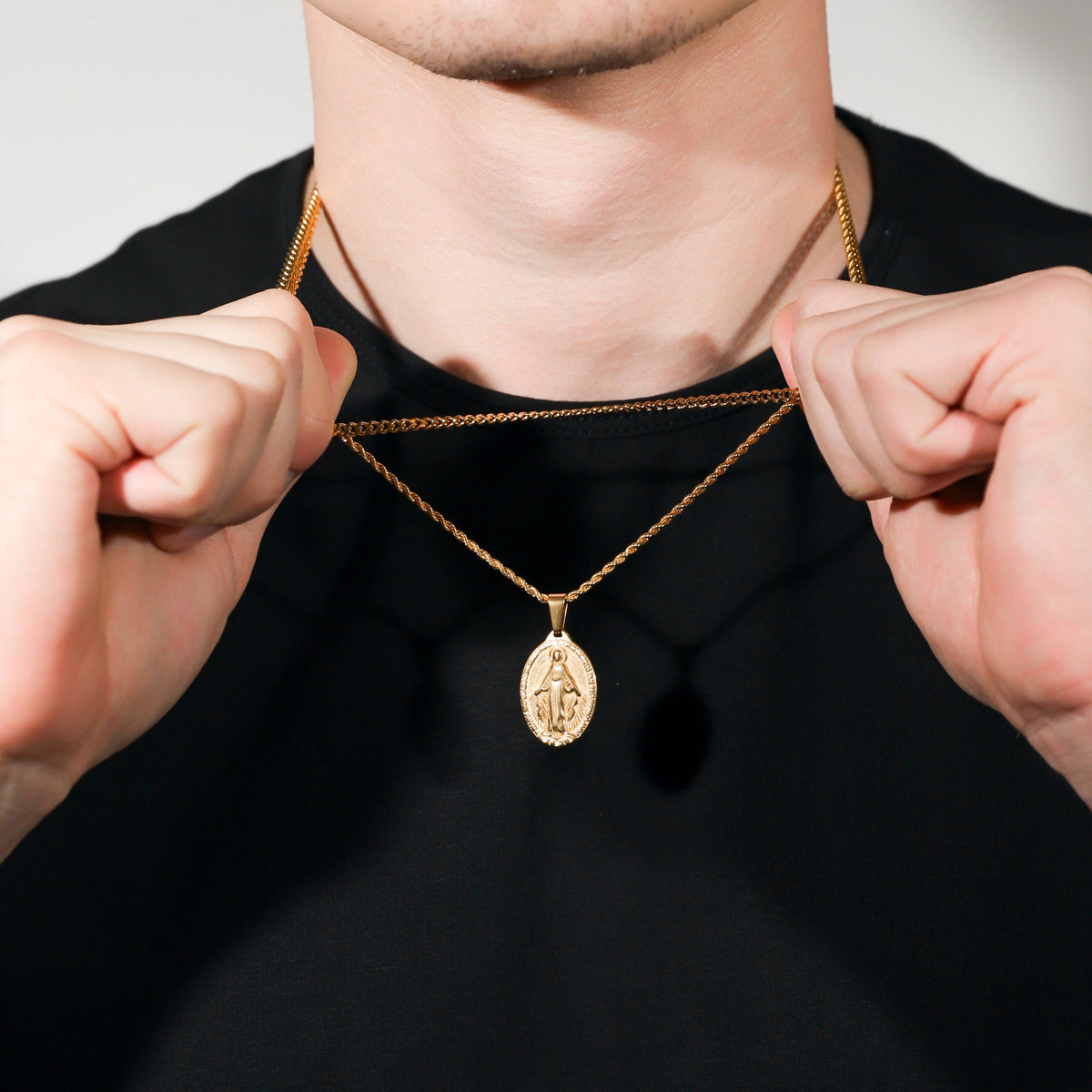 Gold necklace set with two chain layers and oval Saint Mary medallion pendant
