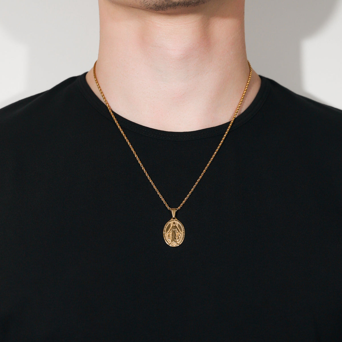 Gold Saint Mary pendant necklace on person, oval charm centered