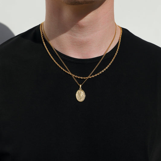 Gold rope chain necklace set with Saint Michael coin pendant centered on chest