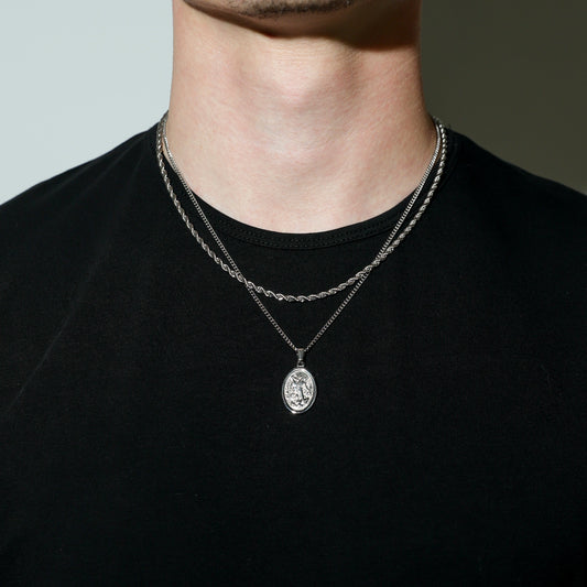 Silver rope chain set with oval Saint Michael pendant on round link chain.