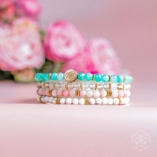 Stack of four beaded bracelets with turquoise, white, and gold accents