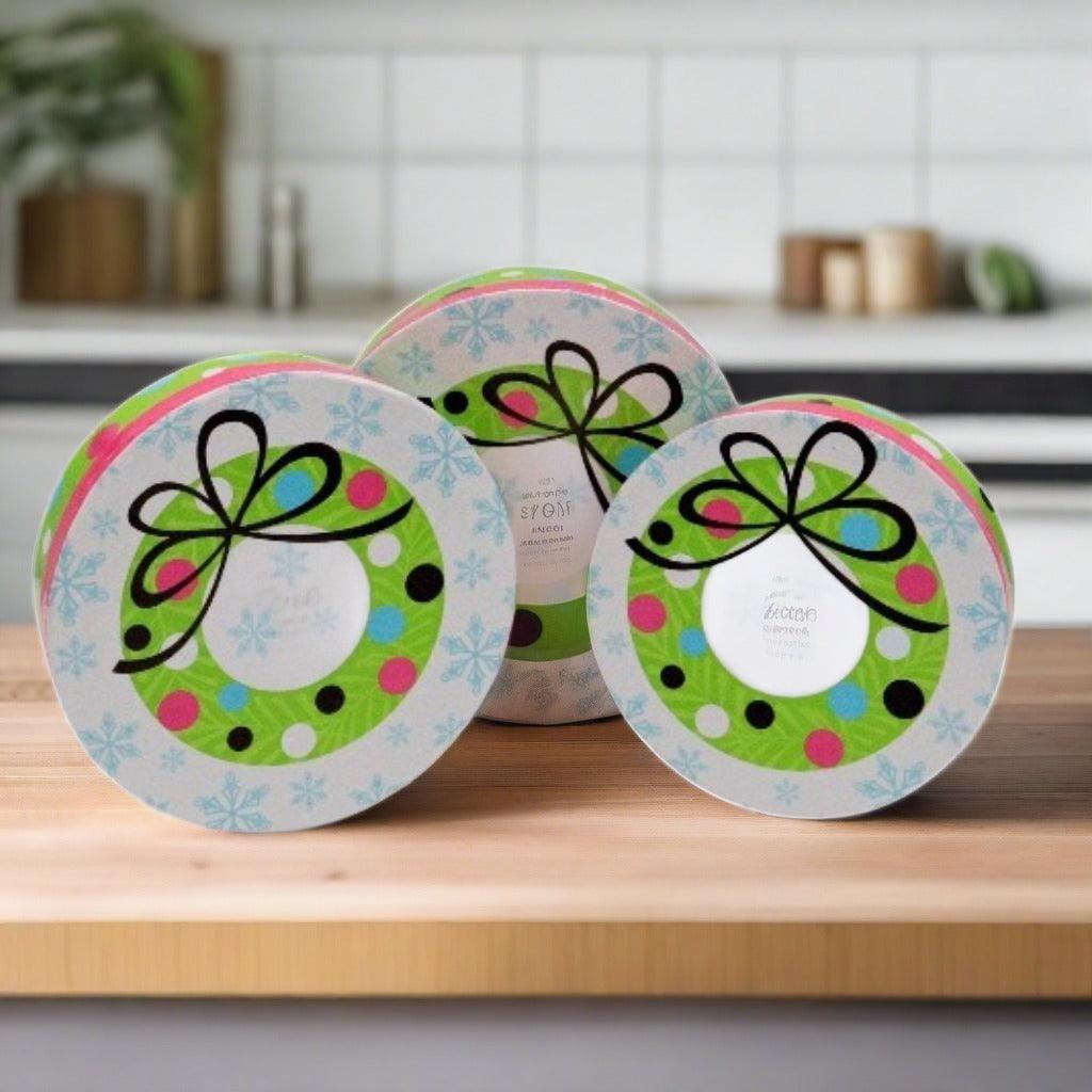 Three round tins for a holiday snack gift tower with polka-dot bows on lids