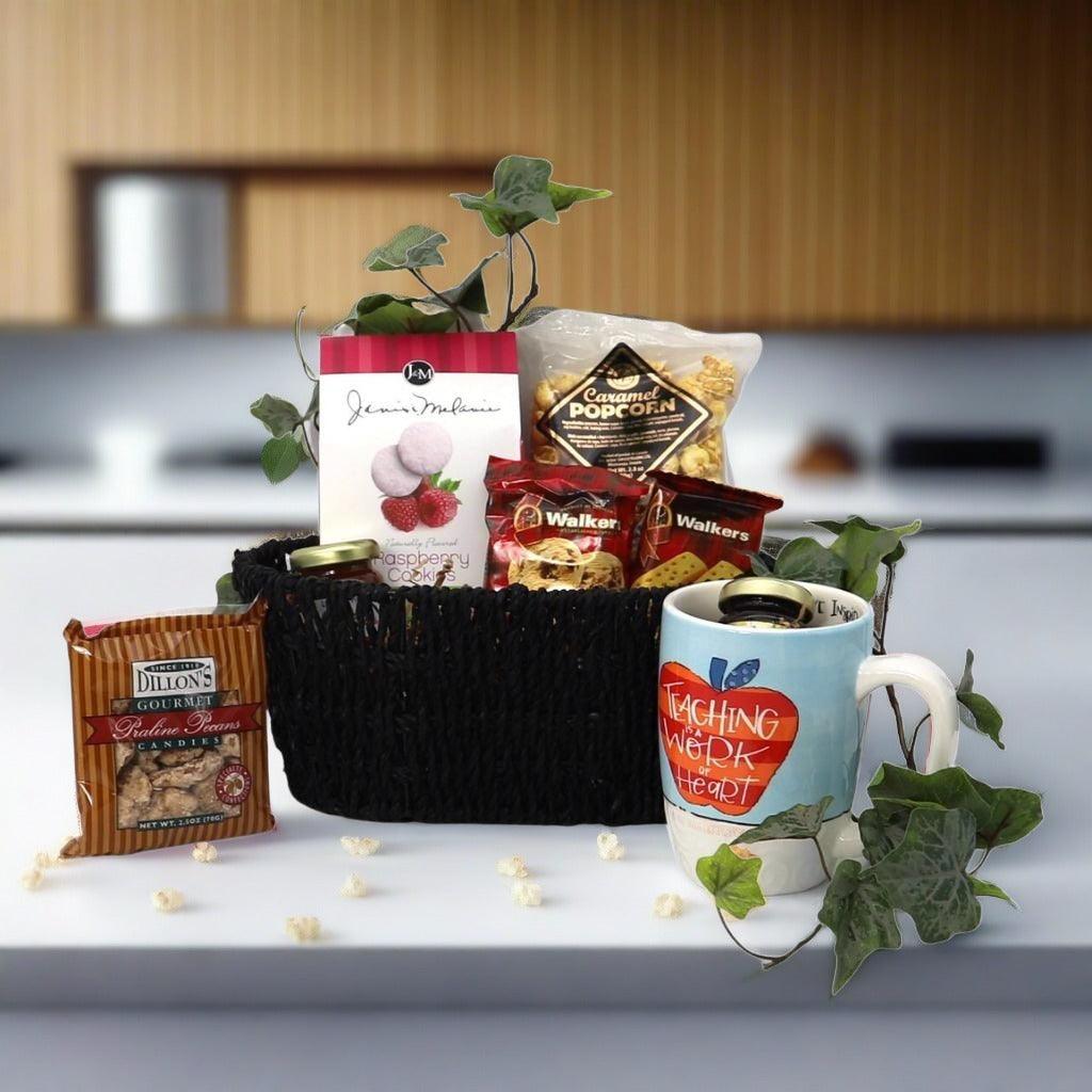 Gift basket with black woven tray, mug, and assorted sweets and snack packages.