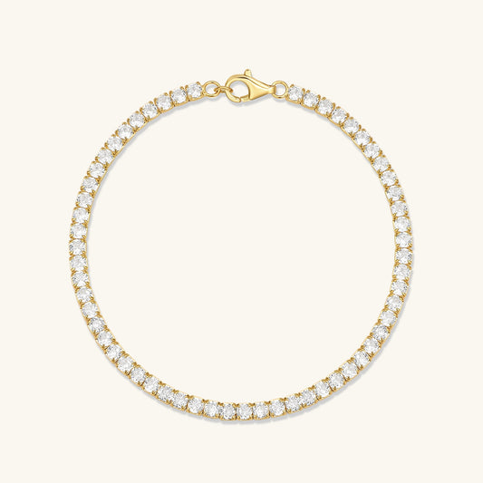 Gold CZ tennis bracelet with round cubic zirconia stones and clasp.