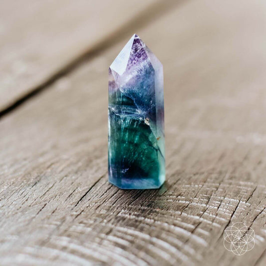 Cleansing crystal point with purple-blue and green marbling, faceted top