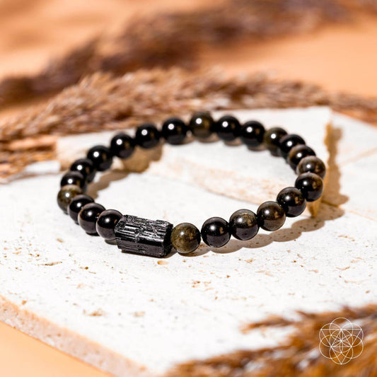 Black beaded bracelet with silver-toned centerpiece and small greenish stone accents