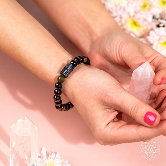 Black beaded bracelet on wrist with silver-toned centerpiece