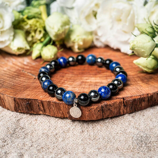 Beaded energy shield bracelet with dark and blue round beads and a small coin charm