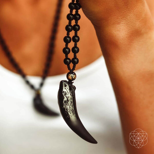 Black beaded necklace with pointed wolf tooth pendant and gold-toned connector