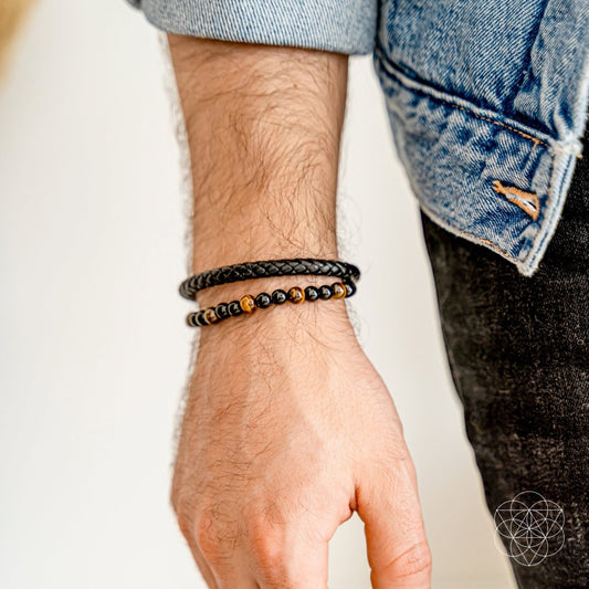 Wrist-worn black and gold beaded bracelet with stacked bead strands