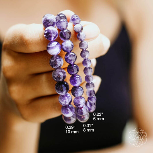 Purple round beaded bracelet held in hand, close-up view
