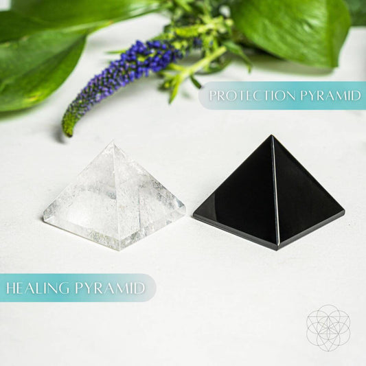 Black and clear crystal pyramid stones with pointed tops on a tabletop