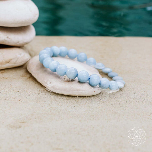 Light blue beaded bracelet with round smooth stones, elastic string