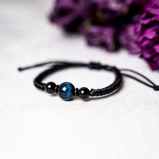 Beaded stability bracelet with dark blue tiger’s eye and black beads on black cord ties