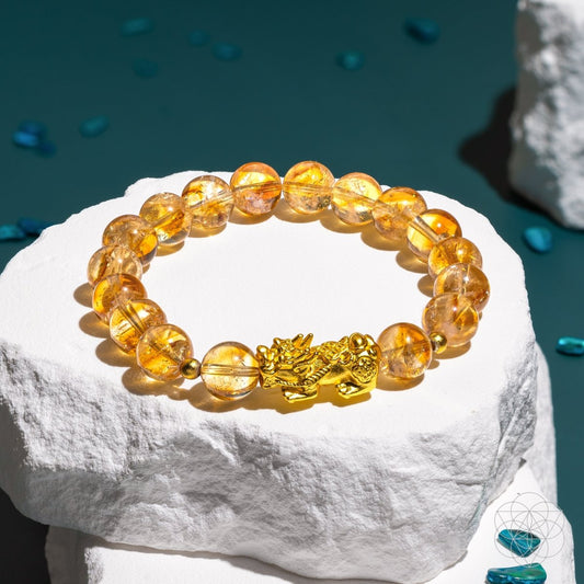 Gold-tone charm bracelet with amber citrine beads and small dragon clasp
