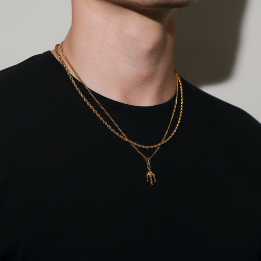 Gold layered necklace with trident charm pendant on center chain