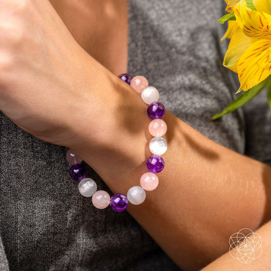 Beaded bracelet on wrist with purple, pink, and white round beads