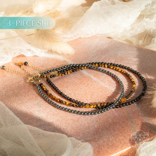 Triple anklet set with black bead strands and small gold beads, adjustable.