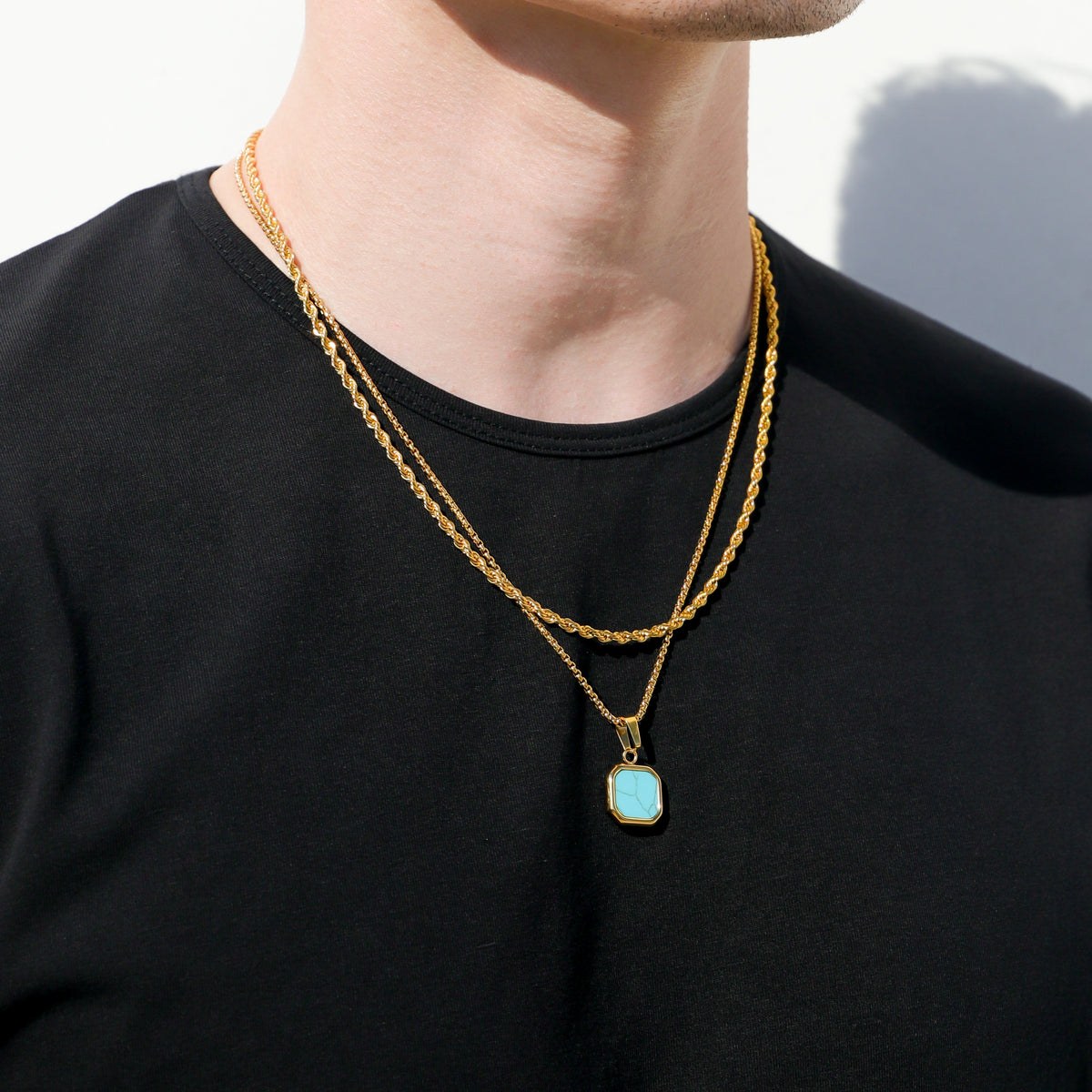 Gold-tone necklace with turquoise square pendant and double chain styling