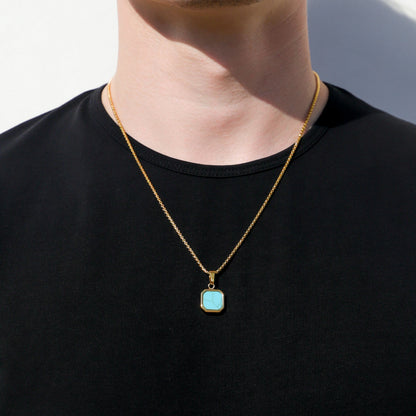 Gold-tone necklace with turquoise square bezel pendant, worn on a man