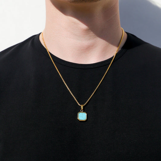 Gold-tone necklace with turquoise square bezel pendant, worn on a man