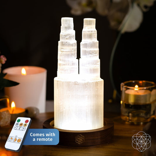 Two-tier selenite lamp with glowing stacked mineral columns on a dark wooden base