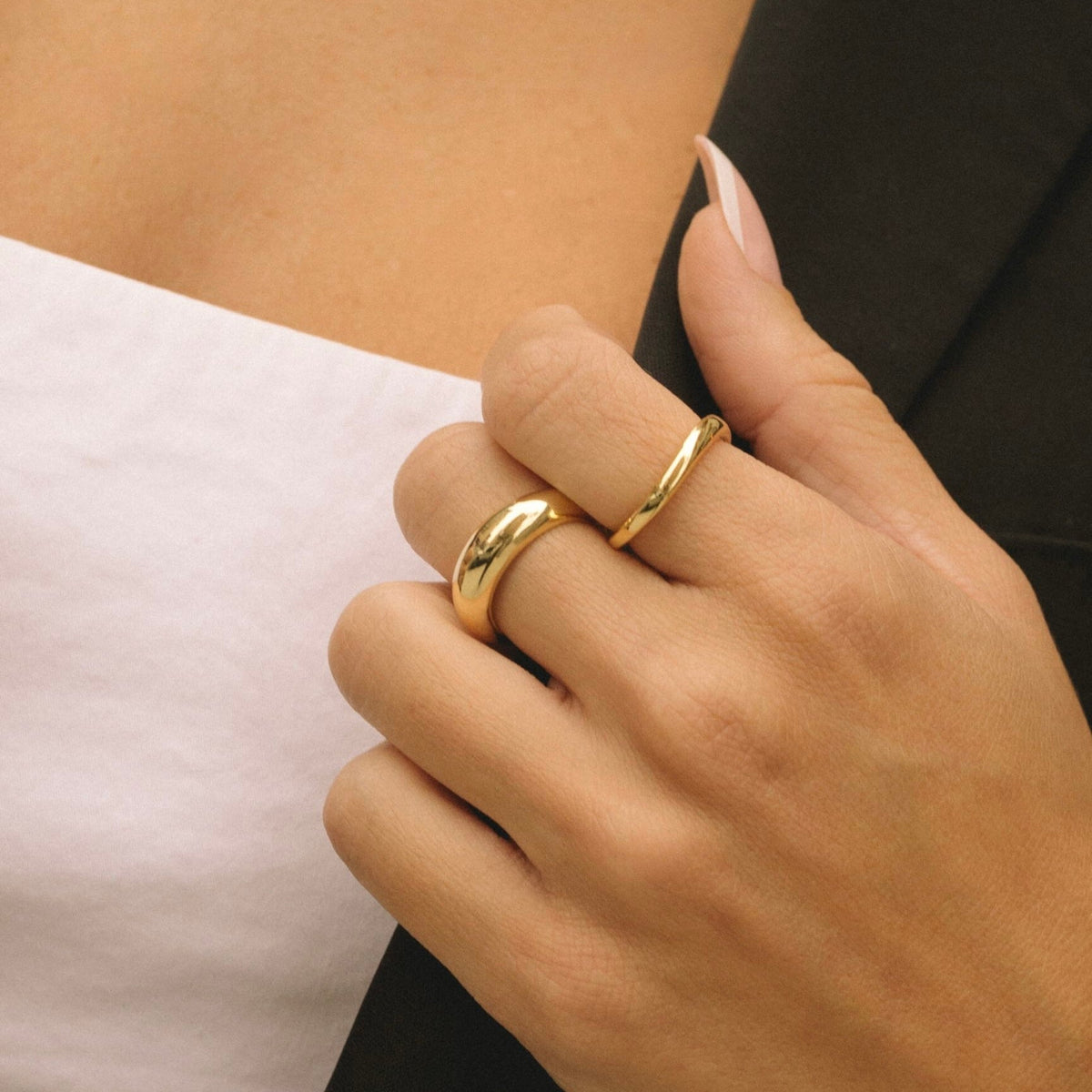Gold wavy dome ring on finger, glossy curved band with raised wavy top