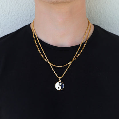 Gold yin yang pendant necklace on black shirt; small round enamel charm in contrast