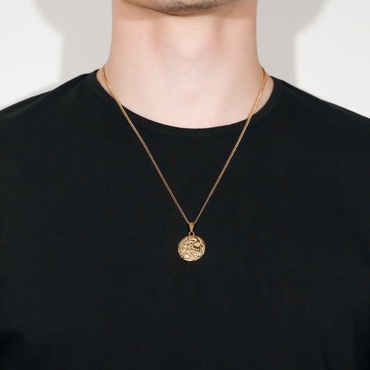 Gold coin pendant on a thin chain necklace, worn at the collar
